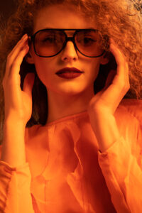 Headshot of a woman wearing orange sunglasses