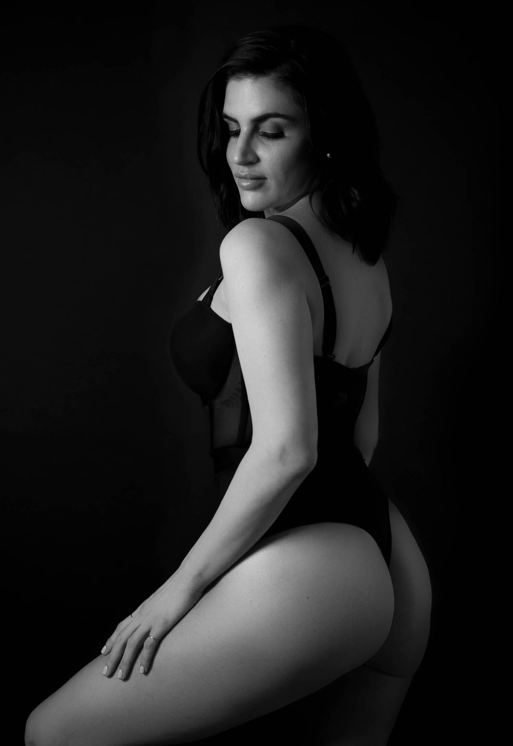 a portrait of a woman wearing a black one suit lingerie