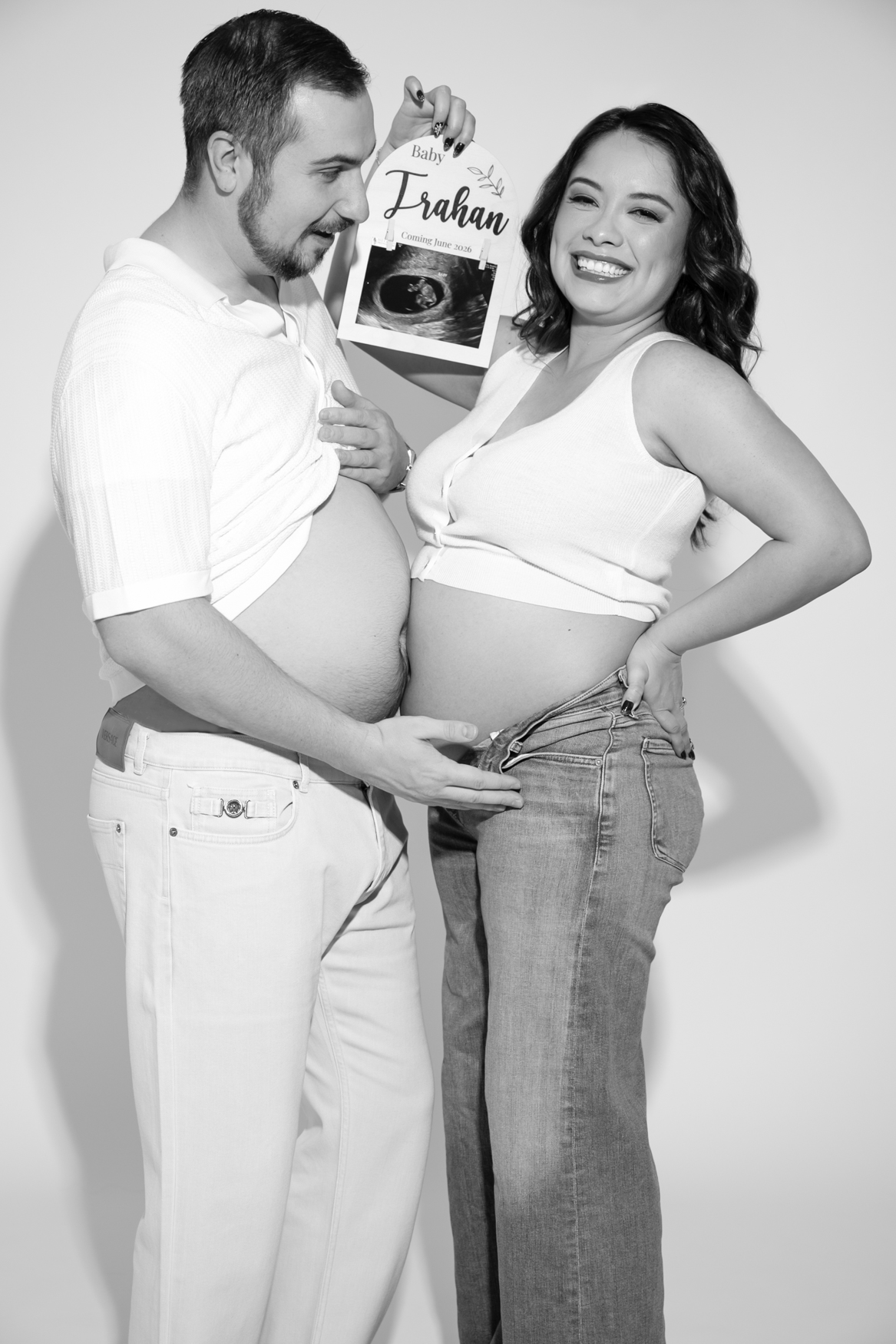 couple showing pregnancy belly and showing sonogram photo pregnancy announcement ideas in Austin